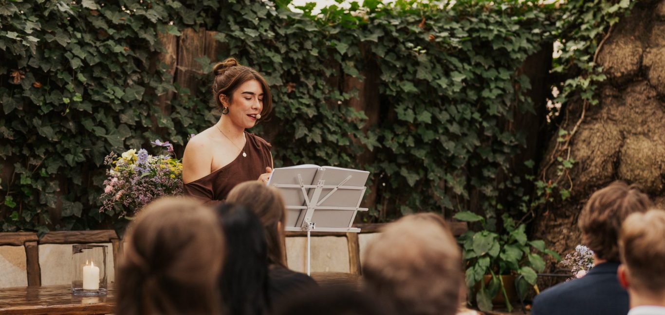 Traurednerin im bastellila Kleid traut ein Paar